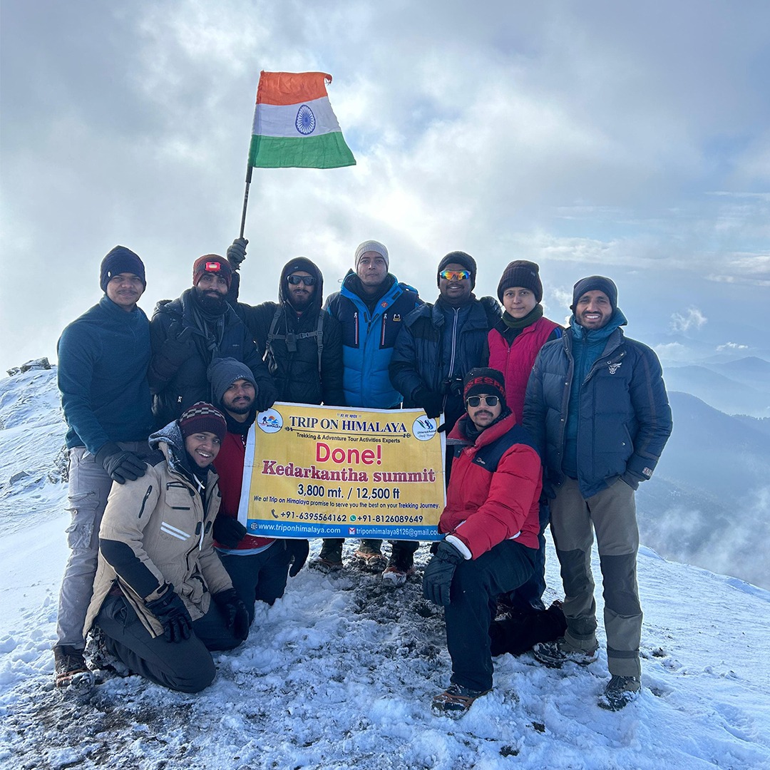 Community group displaying a cause-based banner with Indian Flag at the mountain Kedarkantha Summit