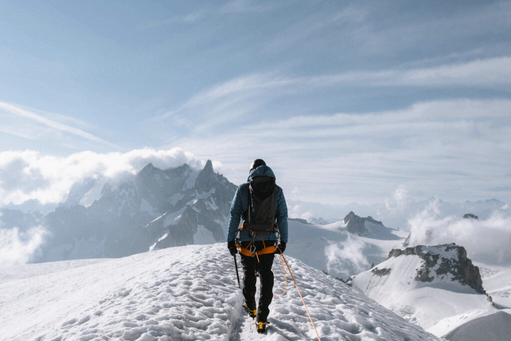 Trekkers crossing Hampta Pass with snow-covered peaks in the background